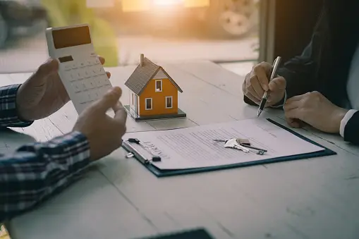 A person uses a calculator while discussing an expert advise and presenting one of the foreclosure solutions.